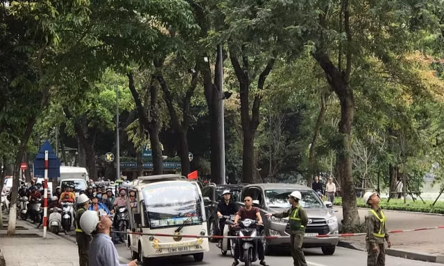 Nhân viên Cty TNHH MTV Công viên Cây xanh Hà Nội giăng dây chắn đường phục vụ cắt tỉa cây xanh.
