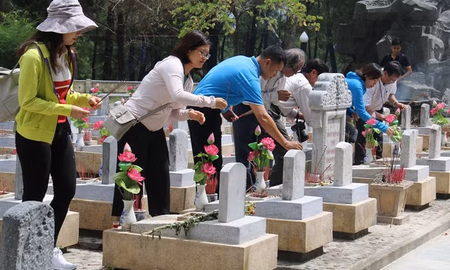 Các thành viên trong đoàn thắp hương tại phần mộ các liệt sĩ. 