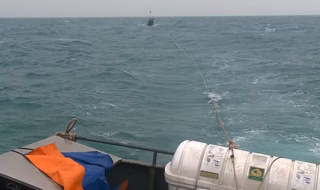 Tàu cá QNa 01059 trên đường được tàu BP 43-1302 lai dắt vào bờ. Ảnh: Hải đội 2 cung cấp.
