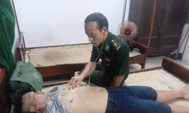Kiểm tra sức khỏe ngư dân bị đắm thuyền sau khi được bộ đội biên phòng và dân địa phương đưa vào bờ an toàn