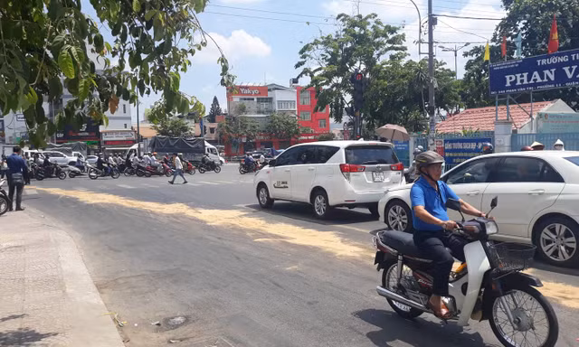 Vết dầu nhớ kéo dài trên đường được lấp bằng cát.