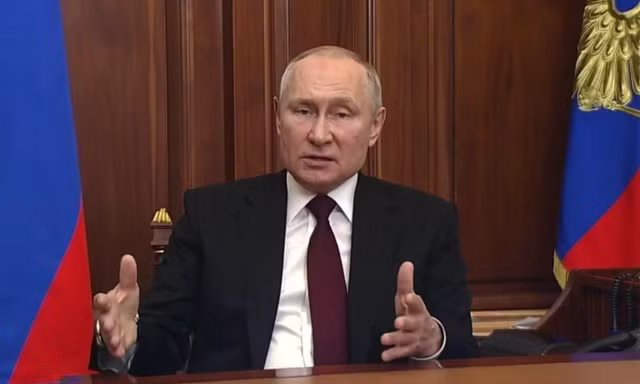 Binh lính Ukraine đứng cạnh một chiếc xe tăng bị hỏng gần Kharkov mà họ nói là của quân đội Nga ngày 24/2. (Ảnh: Reuters)