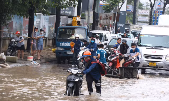 Đại lộ Thăng Long ùn tắc vì ngập, dịch vụ xe kéo đắt khách
