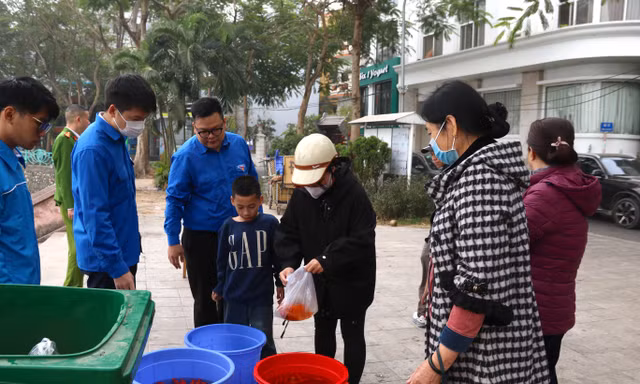 Người Hà Nội thả cá chép vào thùng nhựa 180 lít để tiễn ông Công, ông Táo về trời