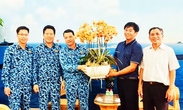 Anh Sang (áo xanh bên phải) tặng hoa lan cho bộ đội Trường Sa