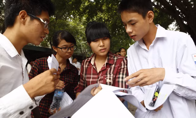 Thí sinh xem lại đề thi sau giờ làm bài môn Hóa học sáng 5/7. Ảnh: Như Ý
