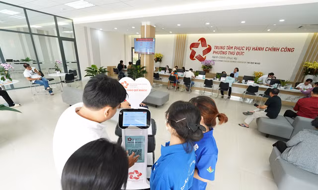 Đến phường, được robot mời nước, kẹo và đưa đi làm thủ tục
