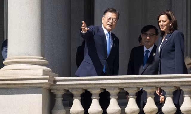 Tổng thống Hàn Quốc Moon Jae-in và Phó Tổng thống Mỹ Kamala Harris nói chuyện trên ban công toà nhà hành pháp Eisenhower trong khu Nhà Trắng ngày 21/5. (Ảnh: AP)