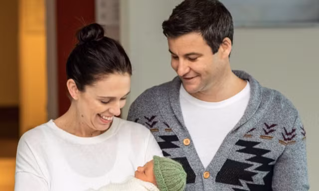 Thủ tướng New Zealand Jacinda Ardern bế con gái bên cạnh bạn trai. (Ảnh: EPA) 