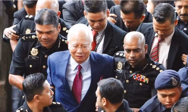 Cựu Thủ tướng Najib Razak rời tòa trước sự bao vây của báo chí. Ảnh: Straits Times.