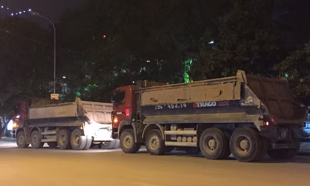 Hàng loạt xe tải nằm chờ hết giờ giới nghiêm trên đường Duy Tân kéo dài (đoạn đối diện công viên Cầu Giấy) chiều tối mỗi ngày né cảnh sát. Ảnh: Nguyễn Hoàn
