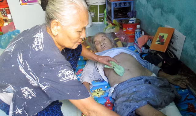 Bà Quế tận tình chăm sóc bà Anh. Ảnh: Giang Thanh