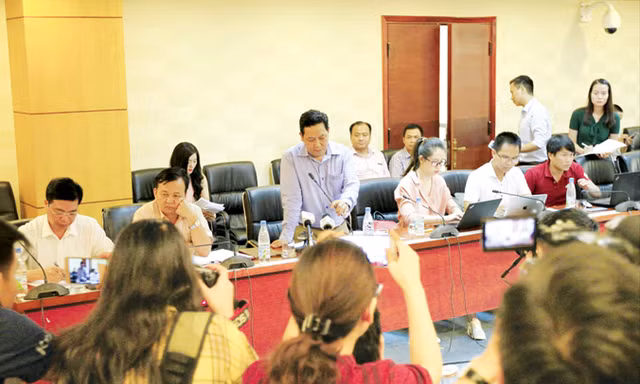 Ông Nguyễn Xuân Quang (đứng giữa) trả lời báo chí xung quanh vụ việc mất tiền. Ảnh: Trường Phong.