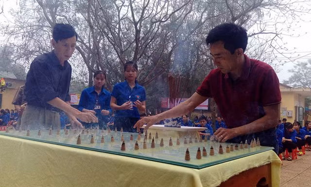 Hai cựu binh cùng học sinh trường Lê Thế Hiếu dâng trầm hương tưởng niệm các liệt sĩ Gạc Ma. Ảnh: Phạm Xuân Dũng