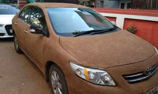 Người phụ nữ Ấn Độ dùng phân bò phủ lên ôtô để chống nóng