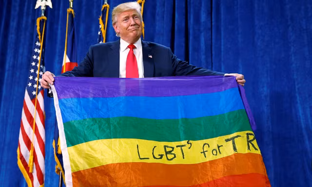 Tổng thống Mỹ Trump cầm lá cờ 7 màu của cộng đồng LGBTQ. Ảnh: Reuters