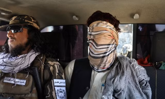 Một tay súng IS (che mặt) bị lực lượng Afghanistan bắt giữ. Ảnh: Reuters