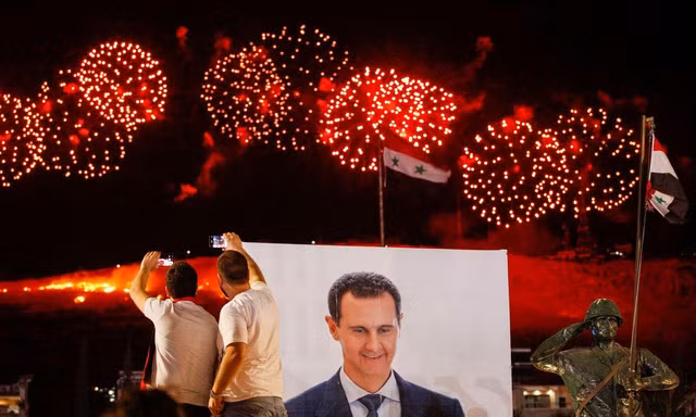 Người Syria ăn mừng chiến thắng vang đội của ông Assad. Ảnh: Reuters