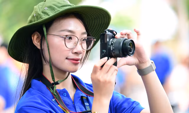 Phía sau chiếc máy ảnh và bông hồng của tình nguyện viên