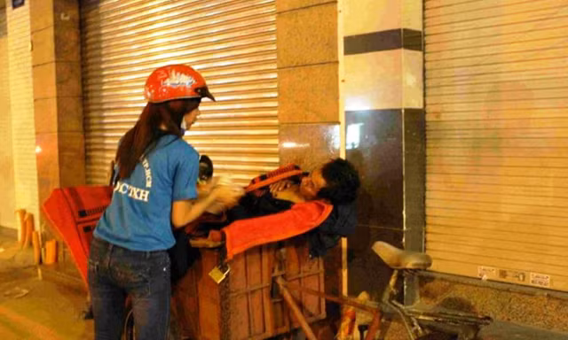Thành viên Đội CTXH của HUTECH phát cháo cho người lao động nghèo trong đêm. Ảnh: Đội Công tác xã hội HUTECH cung cấp.