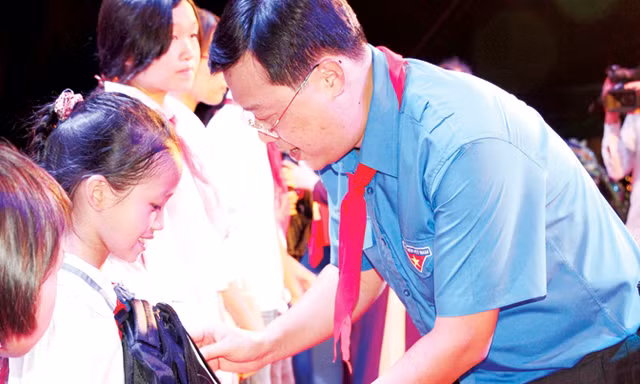 Bí thư thứ nhất T.Ư Đoàn Lê Quốc Phong trao tặng học bổng cho các em học sinh nghèo vượt khó học giỏi. Ảnh: Quang Lộc.