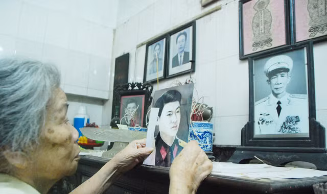 Phu nhân tướng Lư Giang trước ban thờ gia đình có tấm ảnh liệt sĩ Nguyễn Văn Thành.