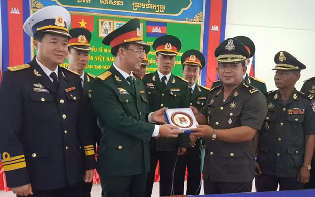Lãnh đạo đoàn sĩ quan trẻ Việt Nam trao tặng logo Thanh niên QĐND Việt Nam cho đại diện Trường Sĩ quan tạo nguồn (Quân đội Hoàng gia Campuchia). 