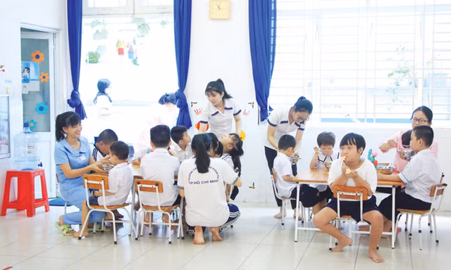 Giáo viên đặc biệt cho trẻ ăn trưa​. Ảnh: Ngô Tùng.