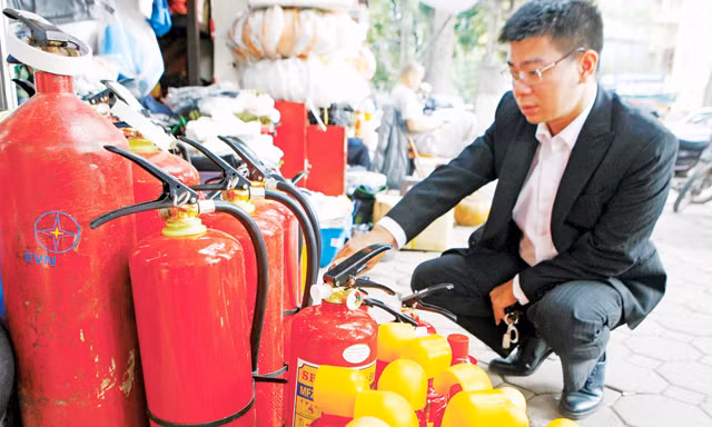 Trang bị bình cứu hỏa mini trên xe ô tô con hiện chỉ để đối phó. Trong ảnh: chọn mua bình cứu hỏa cho xe con ở Hà Nội. Ảnh: Như Ý.