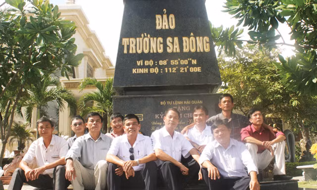 Những cựu binh Trường Sa nhiều thế hệ cùng ngồi bên mô hình cột mốc chủ quyền do anh Trần Văn Xuất làm ngay tại nhà mình. Ảnh Nguyễn Thành.