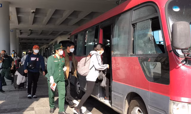 Hành khách lên xe đến địa điểm cách ly sau khi xuống sân bay Cần Thơ. Ảnh: KIM HÀ 