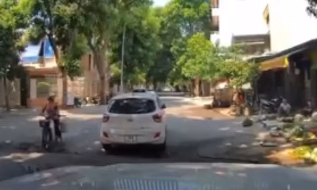 Một phụ nữ vô tư dừng xe ô tô giữa ngã 3 đông người qua lại chỉ để đi chợ