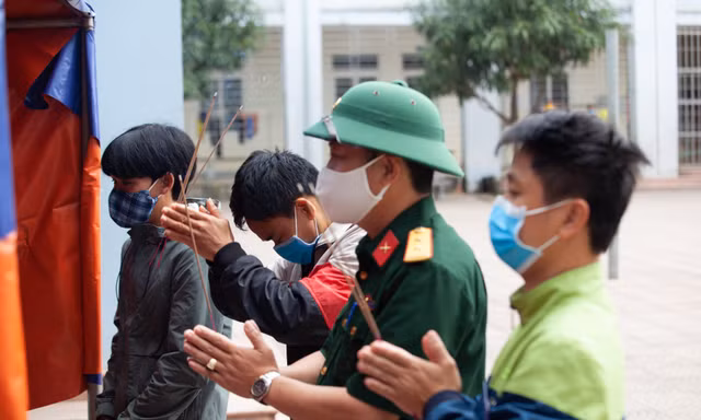 Anh Nguyễn Văn Lộc viếng cha tại bàn thờ được lập tại khu cách ly tập trung trường Phổ thông dân tộc nội trú THPT số 2 Nghệ An
