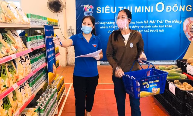 Tình nguyện viên hướng dẫn người dân chọn nhu yếu phẩm tại siêu thị 0 đồng thị xã Sơn Tây.