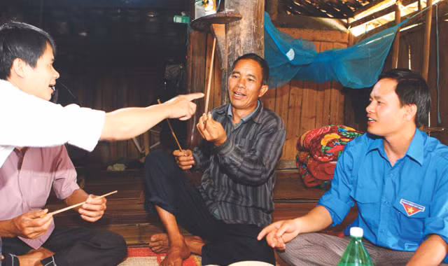 Ông Vương Chính Minh (giữa) mô tả phong tục của người La Chí ở Bản Phùng. Ảnh: Xuân Tùng