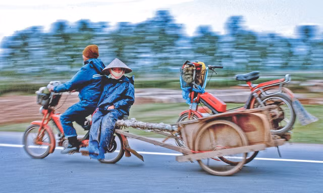 Một cặp vợ chồng ở ngoại thành Hà Nội đang trên đường về nhà sau khi chở hàng vào nội thành. Để tiết kiệm xăng, người chồng chở cả vợ và xe của vợ ở phía sau