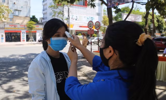 Đo thân nhiệt thí sinh tại điểm thi Trường THPT Phan Đình Phùng (Hà Tĩnh) Ảnh: Thiếu niên Tiền phong 
