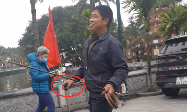 Một người bắt lại cá và rùa phóng sinh ở chùa Trấn Quốc
