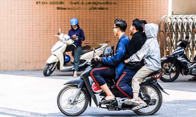 Nhiều học sinh, sinh viên 'đầu trần, kẹp ba' lao vun vút trên đường phố Hà Nội