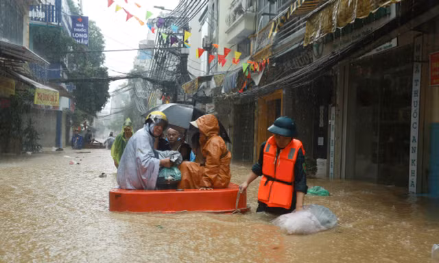 Hà Nội: Nước dâng cao cả mét, người dân dùng thuyền dọn đồ 'chạy lũ'