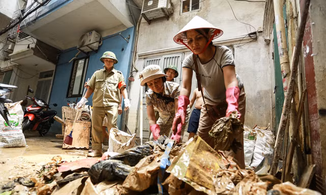 Người dân ven sông Hồng dọn dẹp nhà cửa khi nước rút