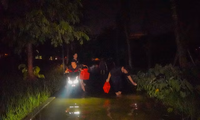 Công viên thành sông sau mưa, người Hà Nội bì bõm bắt cá giữa đêm