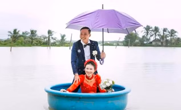 Hình ảnh chú rể đón cô dâu bằng thuyền thúng trong nước lũ. Ảnh: NVCC