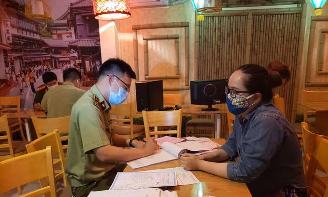 Lực lượng quản lý thị trường làm việc với chủ cửa hàng Michi Sushi & Mì cay vì vẫn bán đồ ăn cho khách bất chấp lệnh cấm