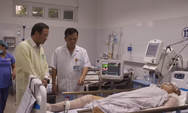 Ông Khuất Việt Hùng, Phó Chủ tịch chuyên trách Uỷ ban An toàn giao thông Quốc gia trao đổi với bác sĩ Huỳnh Đức Phát, Trưởng khoa Gây mê hồi sức - Bệnh viện Đà Nẵng về tình trạng của nạn nhân Nguyễn Văn Tốt