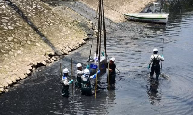 Các kỹ sư và công nhân vận chuyển máy sục khí Nano công nghệ Nhật xuống lòng sông Tô Lịch. Ảnh: Dân trí