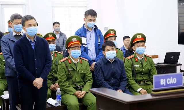 Bị cáo Nguyễn Đức Chung (ngồi) và 3 đồng phạm tại phiên xét xử. (Ảnh: TTXVN).