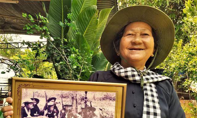 Chị Nguyễn Thị Nga với tấm ảnh chụp Đội nữ du kích Củ Chi năm 1966 Ảnh: T.N.A 