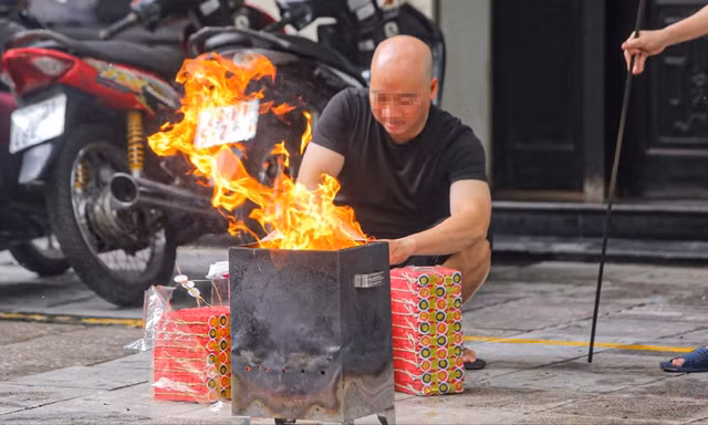 Người dân có thói quen sắp mâm lễ cúng, đốt vàng mã ngay tại vỉa hè, lòng đường Ảnh: DUY PHẠM