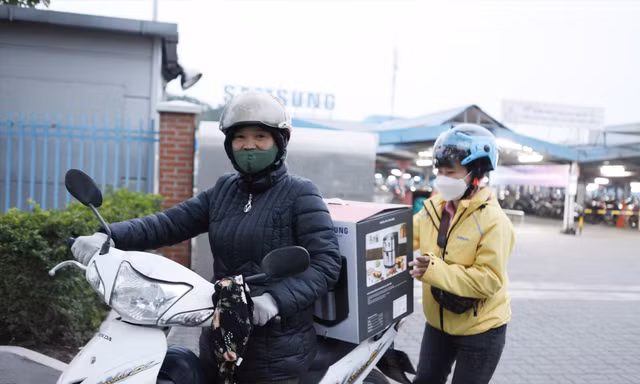 Chị Nguyễn Thị Mười phấn khởi có “cuốc” xe ôm chở một nữ công nhân sau giờ tan ca làm việc ảnh: Nguyễn thắng